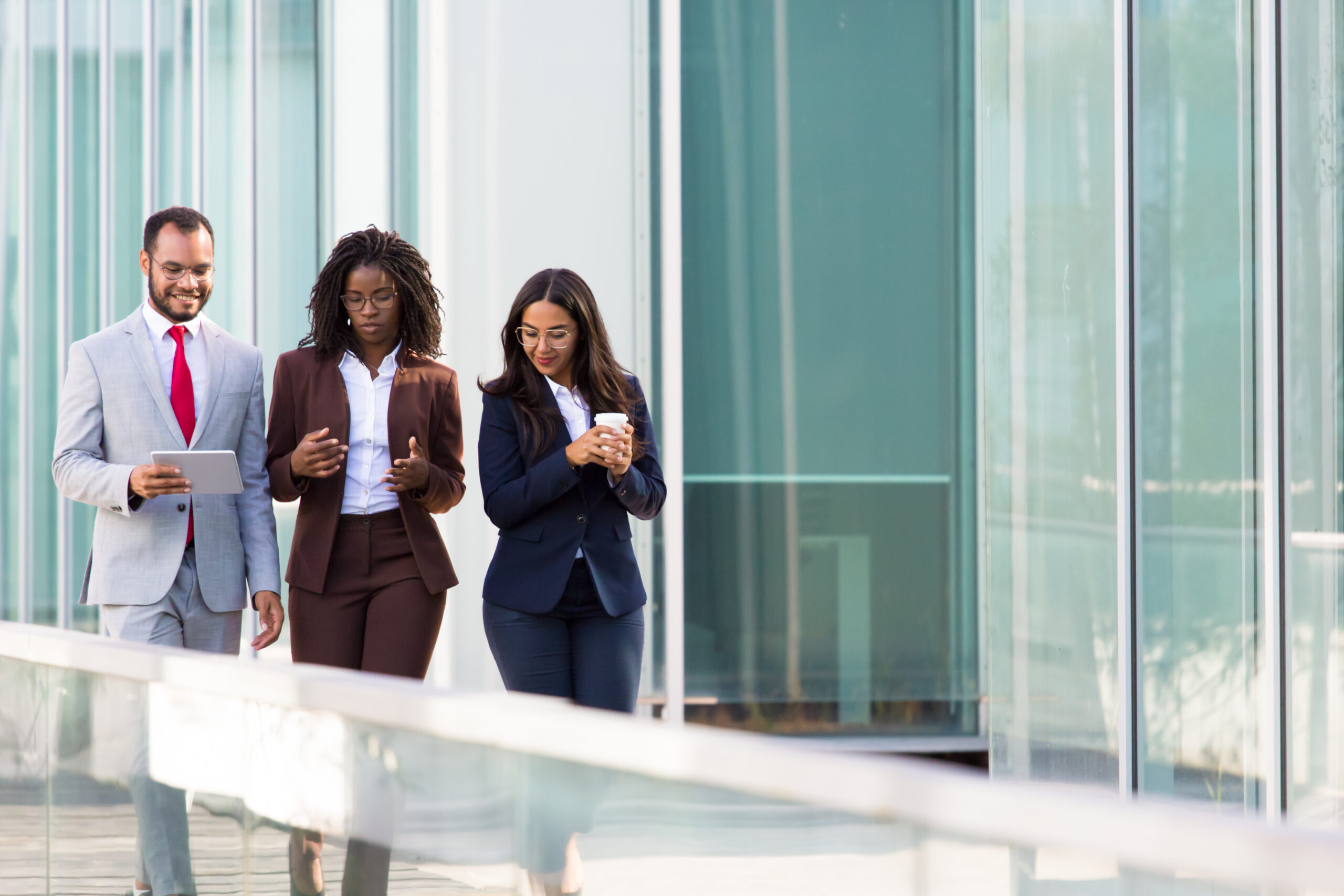 Three colleague walking towards a building